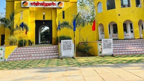 A yellow building with a sign reading 'Vishalgarh' and a QR code on the steps. - AN PERFECT STAYS IN THE LAP OF ARAVALI HILLS (Gurugram)