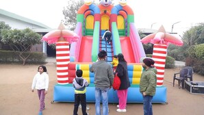 A colorful inflatable play structure with slides and climbing areas, surrounded by a dirt ground and some greenery. - AN PERFECT STAYS IN THE LAP OF ARAVALI HILLS (Gurugram)