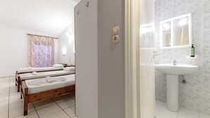 A hotel room with a bed, a bathroom with a sink and mirror, and a shower area. - Apollo Hotel (Zakynthos)