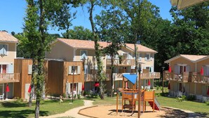 A courtyard with outdoor seating, a playground, and multi-story buildings with balconies. - Apt 5/6 pers.in the countryside, swimming pool, golf, horse riding (Barbaste)