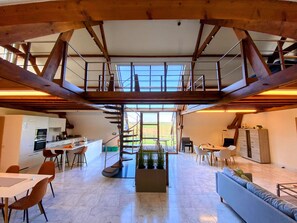 Amplio interior con cocina, comedor y zona de estar. Una escalera conecta dos niveles.