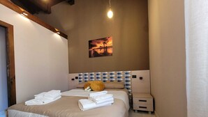 Ein Schlafzimmer mit einem Bett, zwei Nachttischen, einer Wandleuchte und einem gerahmten Bild.