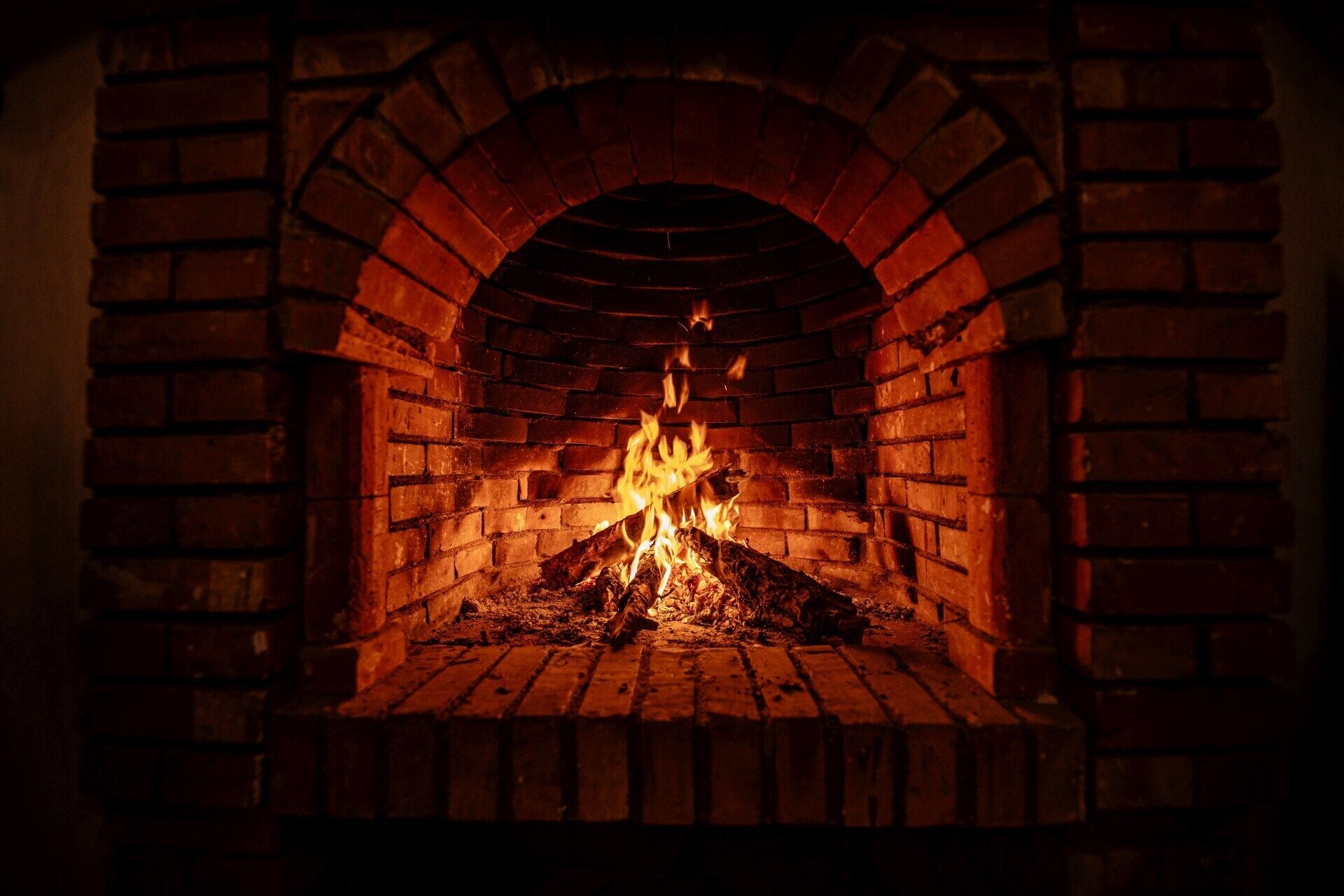 Una chimenea de ladrillo con fuego encendido.