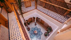 A high-ceilinged atrium with ornate metal railings, a patterned floor, and a central decorative element. - Riad Bleu Azahraa (Safi)