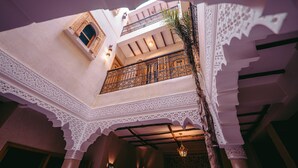 A multi-level interior with ornate white arches and a balcony with a wrought iron railing. - Riad Bleu Azahraa (Safi)