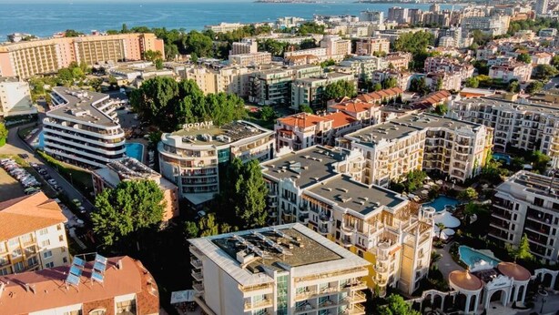 A coastal cityscape with a variety of building styles, including modern and traditional architecture. - Deva Hotel - All Inclusive (Sunny Beach)