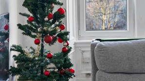 A Christmas tree with ornaments and a star topper in a room with a window. - Leith Walk 2BR | Pool Table & Bath Tub | Tram Stop (Edinburgh)