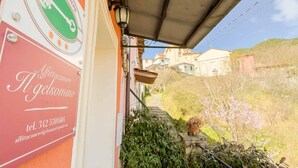 Un edificio con un letrero, una escalera y vistas a casas al fondo.