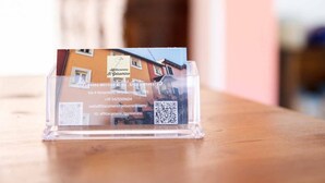 Un étui à cartes de visite comportant un code QR, le nom de l’entreprise et les coordonnées.