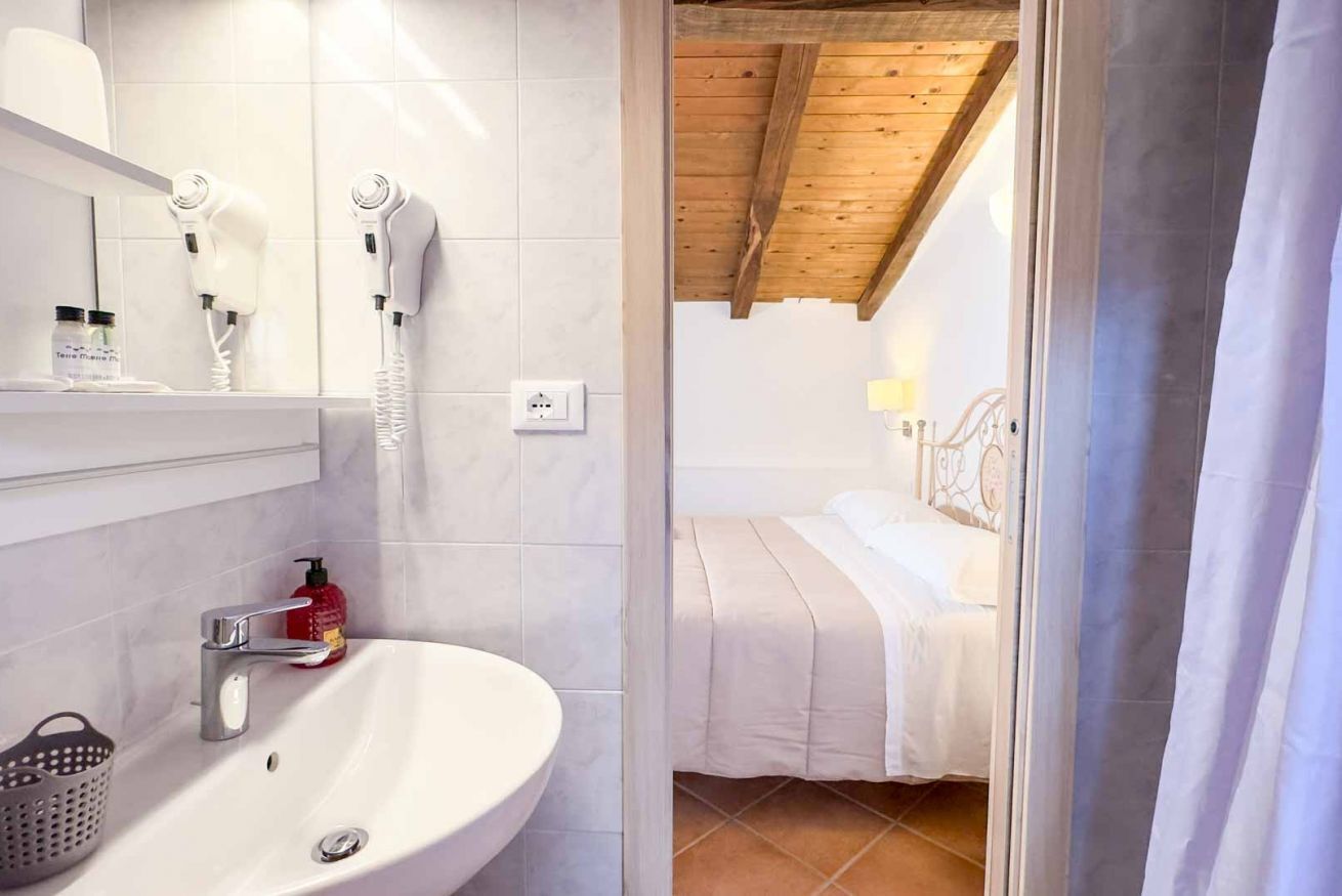 Een badkamer met een wastafel, twee haardroger en een spiegel.