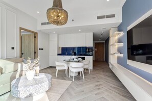 Ein modernes Wohnzimmer mit Essbereich, einer Küche und einem an der Wand montierten Fernseher.