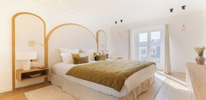 A modern bedroom with a large bed, bedside tables, a mirror, and a view of the city. - Fully Air-Conditioned,View Of The Eiffel Tower-Duplex With Services La Madeleine (Paris)