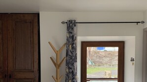 Une pièce avec une armoire en bois, un porte-manteau, une porte donnant sur l’extérieur et un paillasson noir à l’entrée.