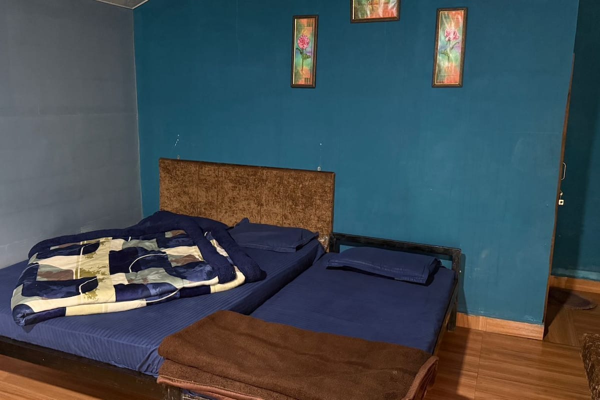 A room with a bed, a wooden headboard, and two framed pictures on the wall.