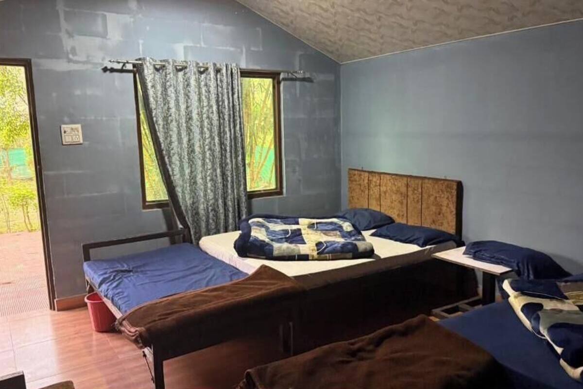 A room with a bed, a small table, and a window with curtains.
