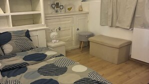 A bedroom with a bed, a dresser, a bench, and a staircase. - Getaway & wellness accommodation Massage Jacuzzi Sauna (Ravenel)
