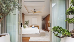 A modern bedroom with a bed, bedside tables, and a ceiling fan. - Luxury 4BR Pool Villa Botanica Prestige (Choeng Thale)