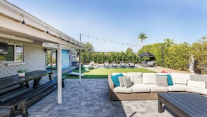 Une terrasse avec un canapé, une table et un banc.