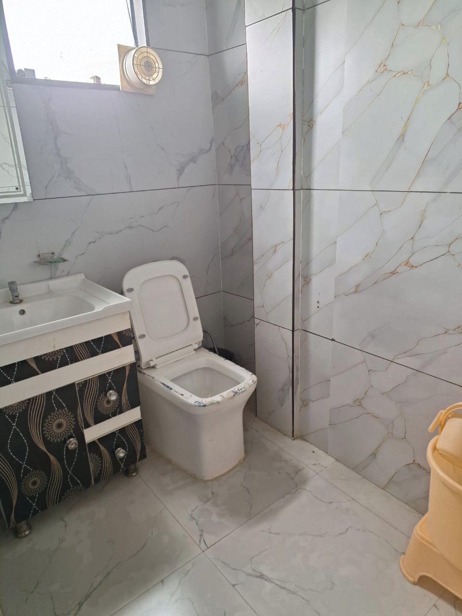 Un baño con inodoro, lavamanos y espejo.