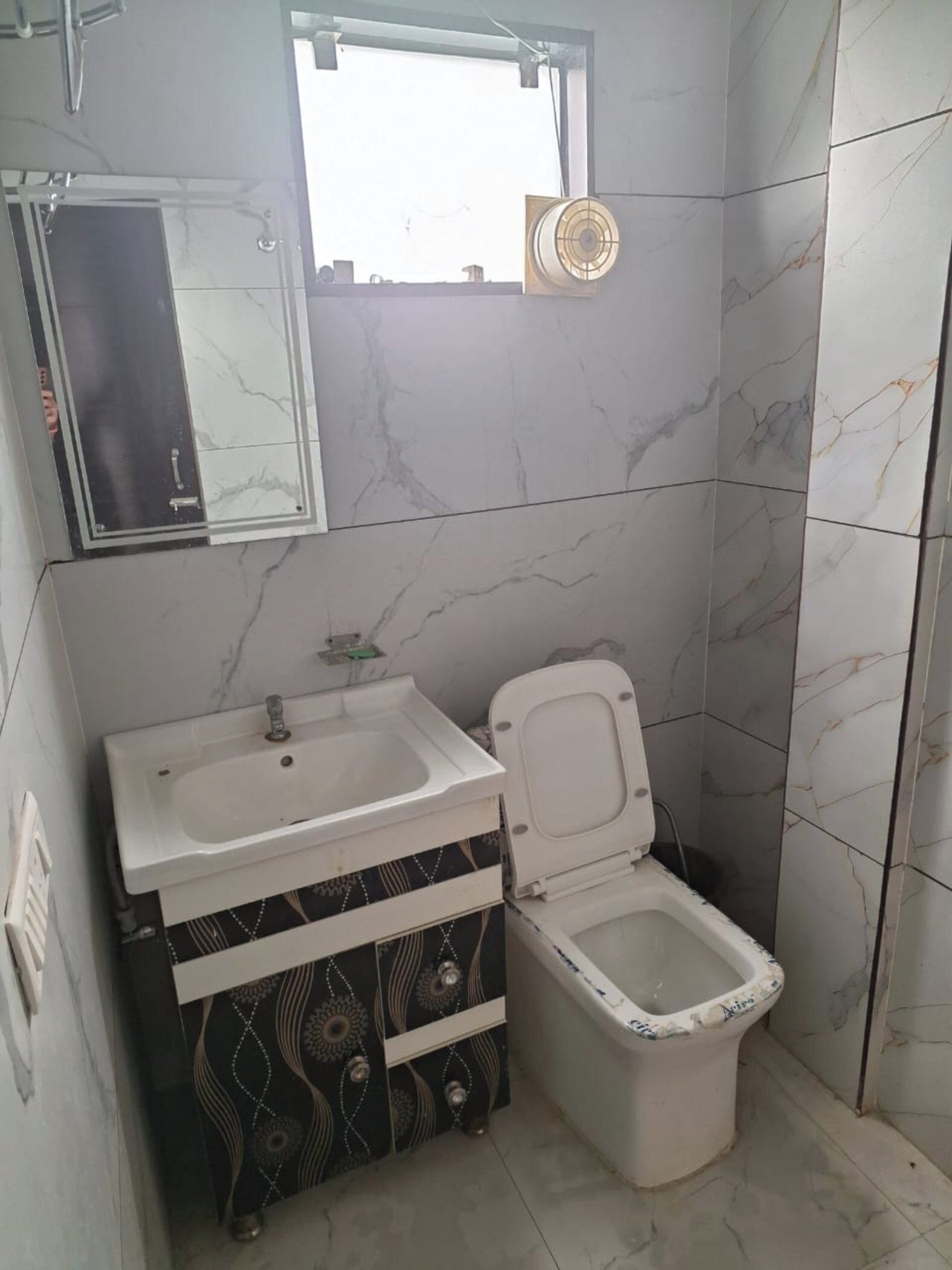 Un baño con lavamanos blanco, inodoro y espejo.