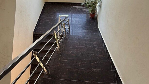 A staircase with metal railings leading to a room with a large window.