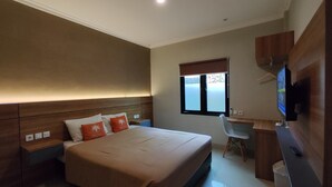 A bedroom with a bed, bedside tables, a desk, a chair, a television, and a window. - HOTEL URBAN LATIFA YOGYAKARTA (Depok)