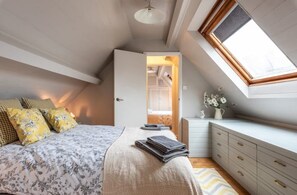 A bedroom with a bed, bedside table, dresser, and a skylight. - Cosy country cottage, a rural idyll near Dorking & Gatwick - 30 miles to London (Dorking)