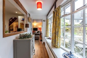 A hallway leading to a living room with a large window, a mirror, and a wooden ceiling. - Cosy country cottage, a rural idyll near Dorking & Gatwick - 30 miles to London (Dorking)