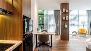 Eine moderne Küche mit Essbereich, Holzvertäfelung und Blick durch große Fenster.