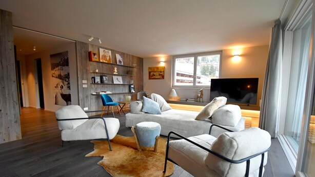 Una sala de estar moderna con un conjunto de sofá, una mesa de centro y un televisor.
