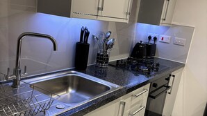 A modern kitchen with a stainless steel sink, a coffee maker, and a dishwasher. - Stylish 1 Bedroom Apartment in East Croydon - Fast Link To Gatwick Airport (Croydon)