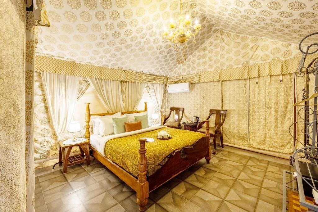 A bedroom with a wooden bed, a nightstand, a lamp, and a chandelier.