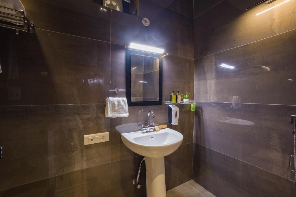 A modern bathroom with a white sink, a mirror, and a towel rack.