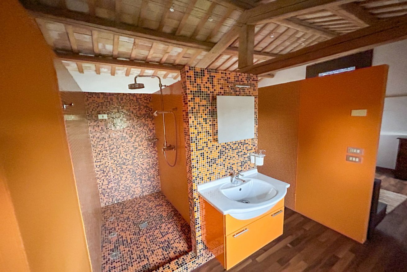 Un baño con ducha, lavabo y pared de azulejos.