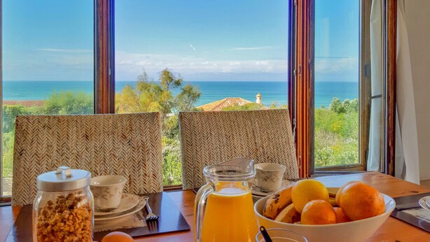 A table with breakfast items and a view of the ocean.