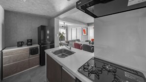 Una cocina moderna con estufa a gas, un lavamanos y un refrigerador.