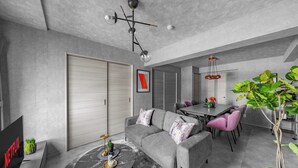 Una sala moderna con sofá, mesa de centro y comedor con sillas.