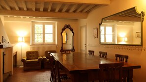 A dining room with a long wooden table, six chairs, a fireplace, and a mirror on the wall. - B&B Villa Lucchese, portion of private villa in the hills of Lucca (Arsina)