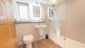 Ein modernes Badezimmer mit Toilette, Waschbecken und einer Duschkabine.