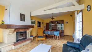 A living room with a fireplace, a dining area, and a kitchen. - Cure or vacation a quiet house with a view of the castle (Jonzac)