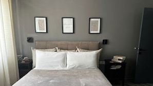 A bed with a headboard, two bedside tables, and three framed artworks on the wall. - Luxury 3BR Escape - Pools and Gardens (Qala)