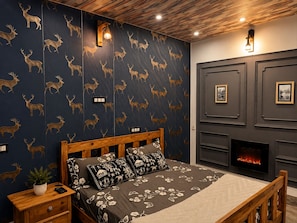 A bedroom with a bed, bedside tables, a fireplace, and wall-mounted artwork. - The Celebrè- A Little Castle Homestay  (Tehri)