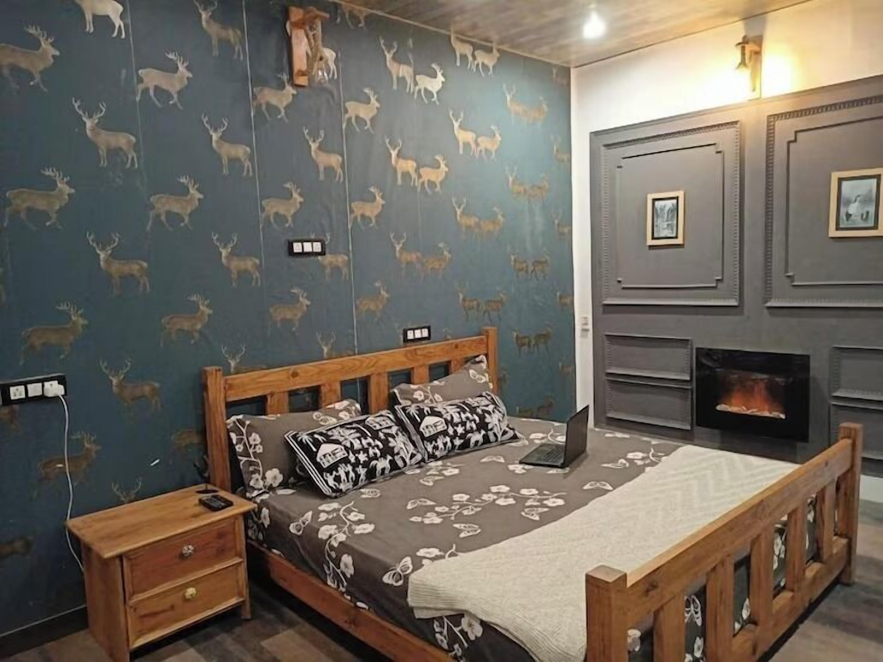 A bedroom with a bed, nightstand, and a fireplace.