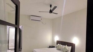 Ein Schlafzimmer mit einem Bett, einem Deckenventilator und einem Nachttisch.