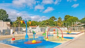 A water play area with various colorful structures and a fenced perimeter. - Mobile home, AC, pets welcome - 6 guests (Saint-Cyprien)
