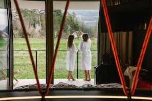 A room with a large window overlooking a grassy area. - Wochtla Buam (Brunico)