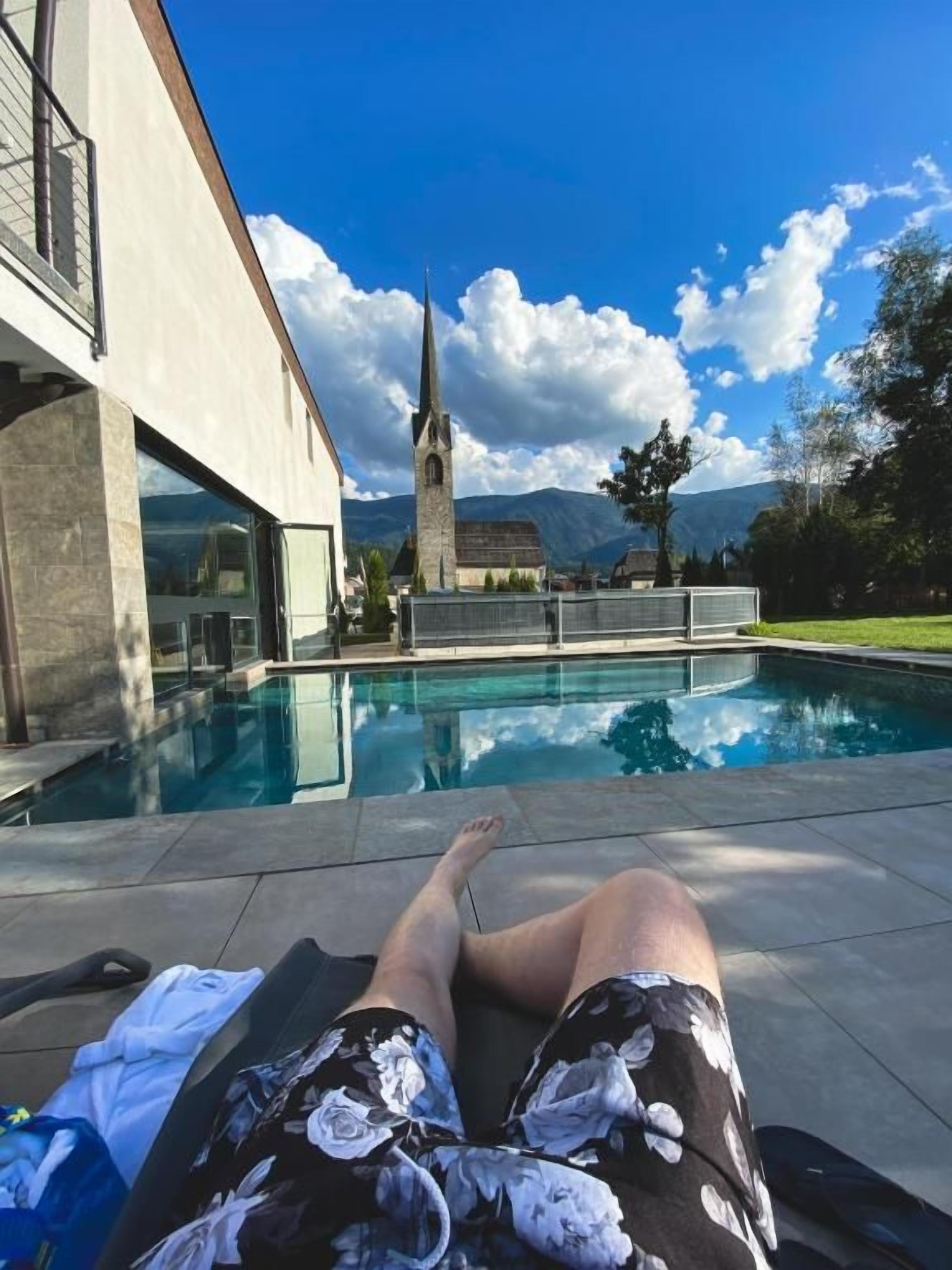 Une vue sur la piscine, avec un bâtiment et une église en arrière-plan.