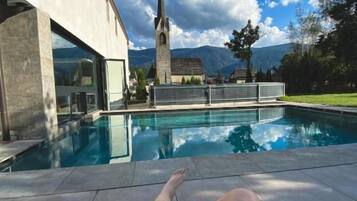 Vista de la piscina con un edificio e iglesia al fondo.