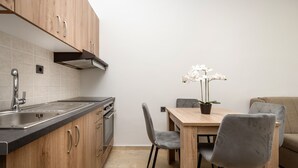 Una cocina moderna con armarios de madera, un lavamanos y un comedor con mesa y sillas.
