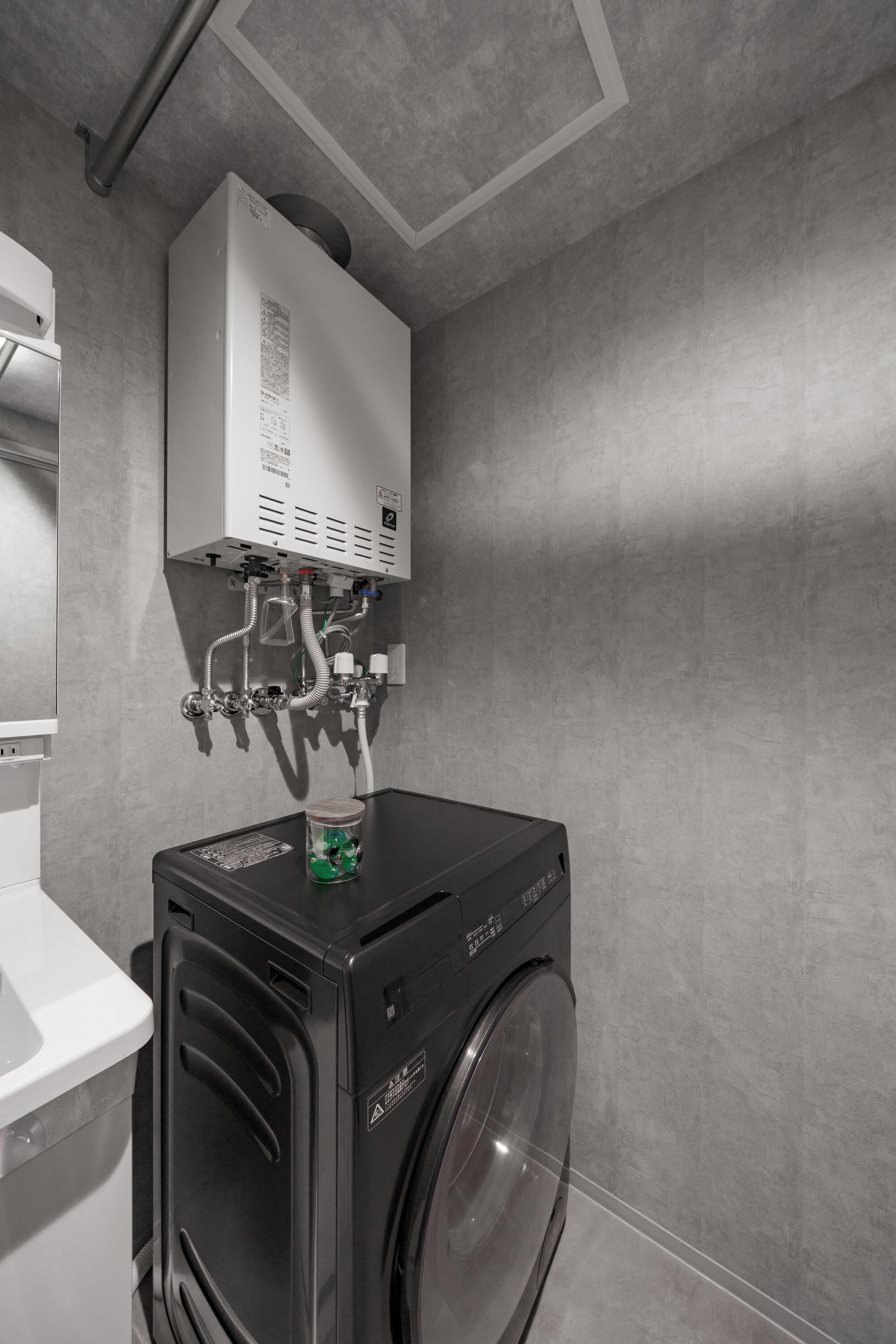 A compact laundry area with a washing machine, a dryer, and a water heater.
